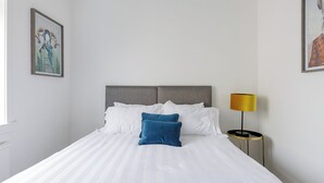 A hotel room with a bed, a bedside lamp, and two framed artworks on the walls. - The Paddock - UK52288 (Auchincruive)
