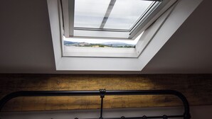 A skylight above a bed with a wooden headboard and metal frame. - 6 bedroom accommodation in Carnforth (Carnforth)