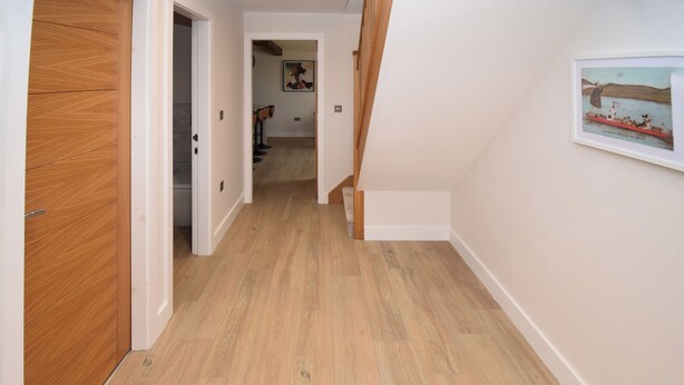 A hallway with wooden flooring and a staircase leading to another room. - 6 bedroom accommodation in Carnforth (Carnforth)