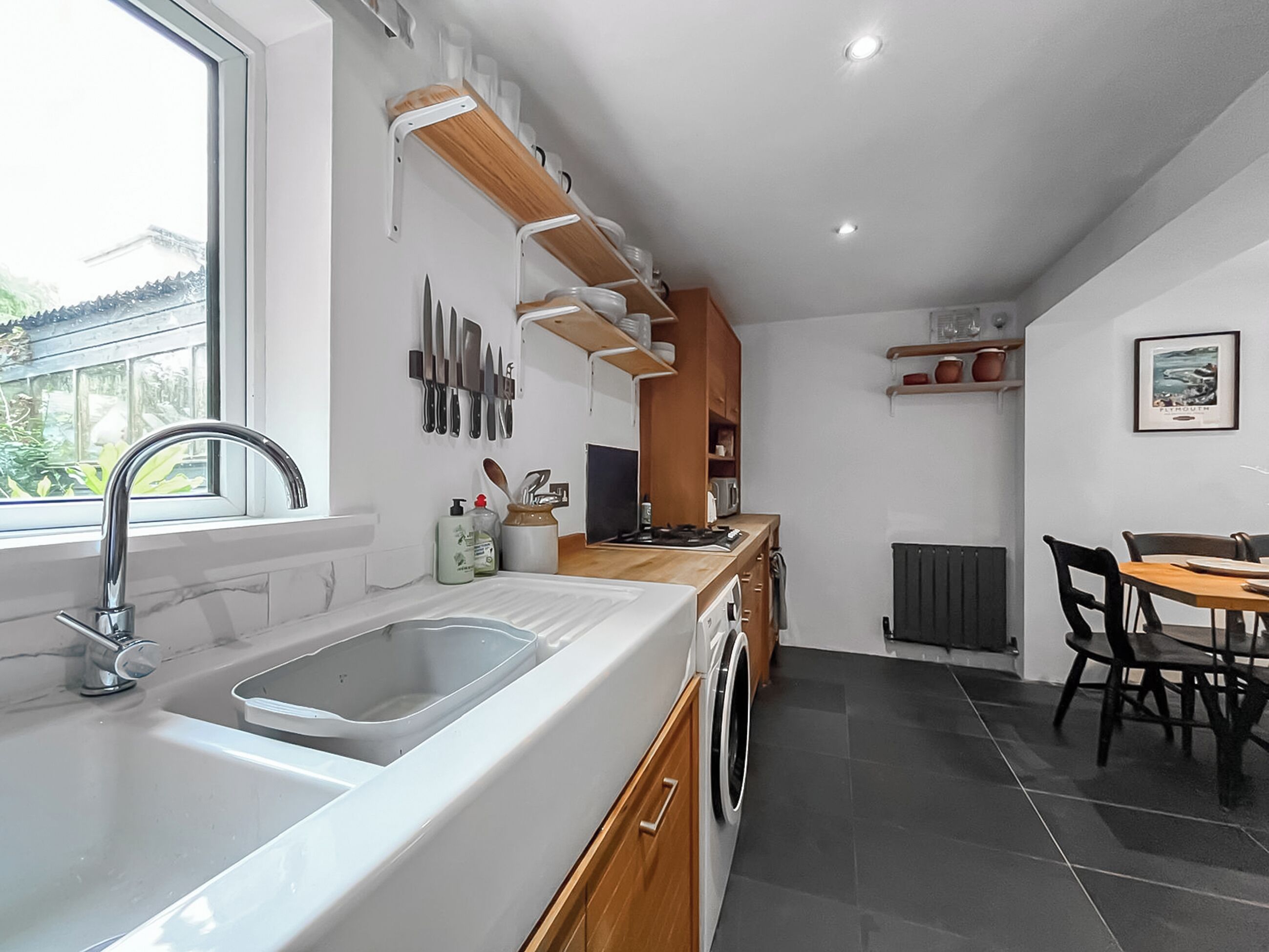 A modern kitchen with a sink, stove, and dining area.