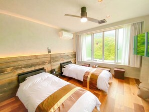 A hotel room with two beds, a ceiling fan, an air conditioning unit, a window with a view, and a flat-screen TV mounted on the wall. - LiVEMAX RESORT TSUKUBASAN (Tsukuba)