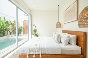 Une chambre avec un grand lit, une vue sur une piscine et une porte en bois.