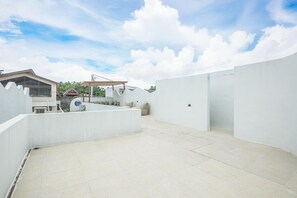 A spacious outdoor area with a flat roof, a covered seating area, and a view of surrounding buildings. - Brand New 2br Uluwatu Villa 2 Mins to Beach (Pecatu)