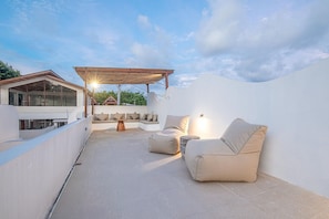 A rooftop terrace with a covered seating area, a dining table, and a view of the surrounding landscape. - Brand New 2br Uluwatu Villa 2 Mins to Beach (Pecatu)