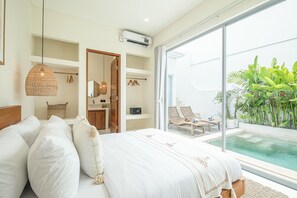 A bedroom with a large bed, a hanging light fixture, and a view of a swimming pool. - Brand New 2br Uluwatu Villa 2 Mins to Beach (Pecatu)