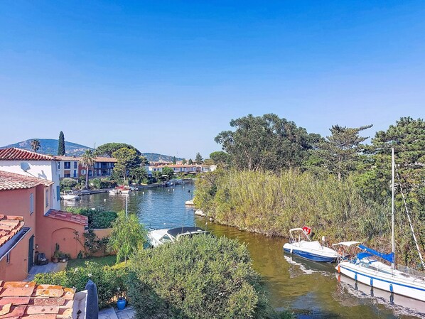 A river with boats, buildings, and trees. - L'Annonciade by Interhome (Port Cogolin)