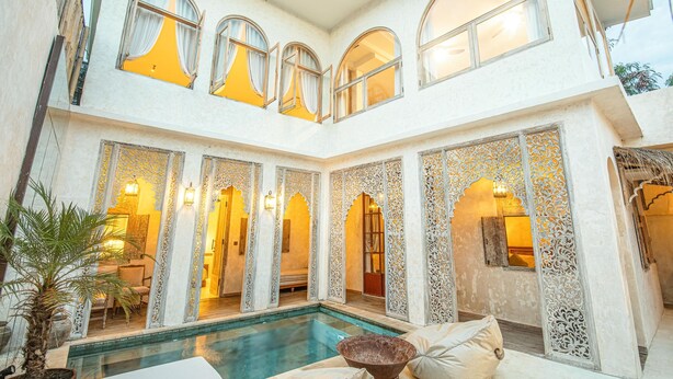 Ein mehrgeschossiges Interieur mit Pool, Rundbogenfenstern und aufwendigen Wandverzierungen.