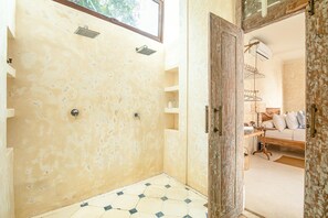 Ein Badezimmer mit Dusche, Waschbecken und Fenster.