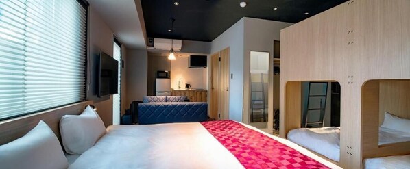 A modern hotel room with a large bed, a seating area, and a separate sleeping area.