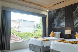A modern hotel room with a large window, two beds, a marble wall, and a view of a building outside. - Suriwathi Hotel and Villas Legian (Legian)