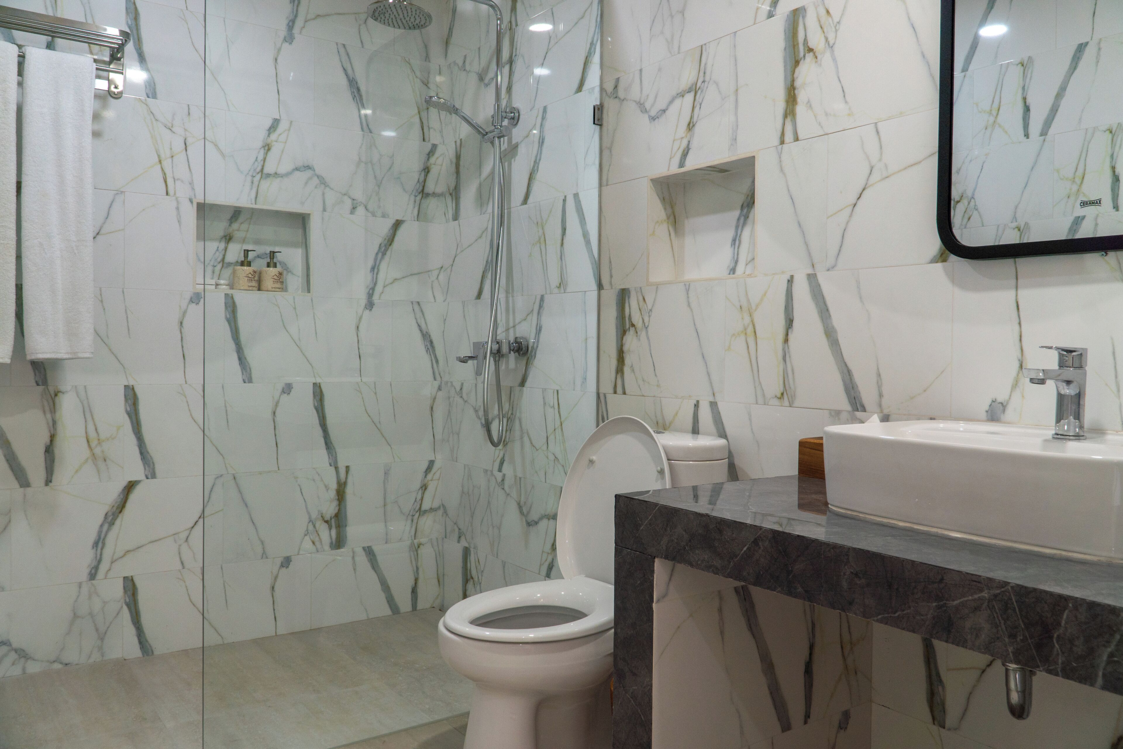 A bathroom with a toilet, a shower, and a sink.