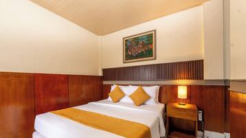 Ein Hotelzimmer mit Bett, Nachttisch, Lampe und einem Bild an der Wand.