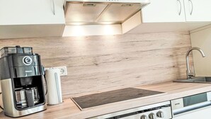 A modern kitchen with a coffee maker, a built-in stove, and a sink. - Herzwerk Schwalenberg by Interhome (Schwalenberg)