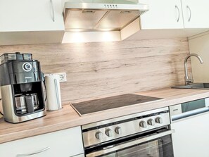 A modern kitchen with a coffee maker, a built-in stove, and a sink. - Herzwerk Schwalenberg by Interhome (Schwalenberg)