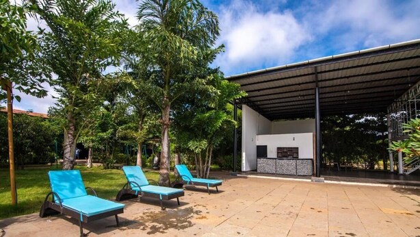 An outdoor seating area with lounge chairs and a covered structure.