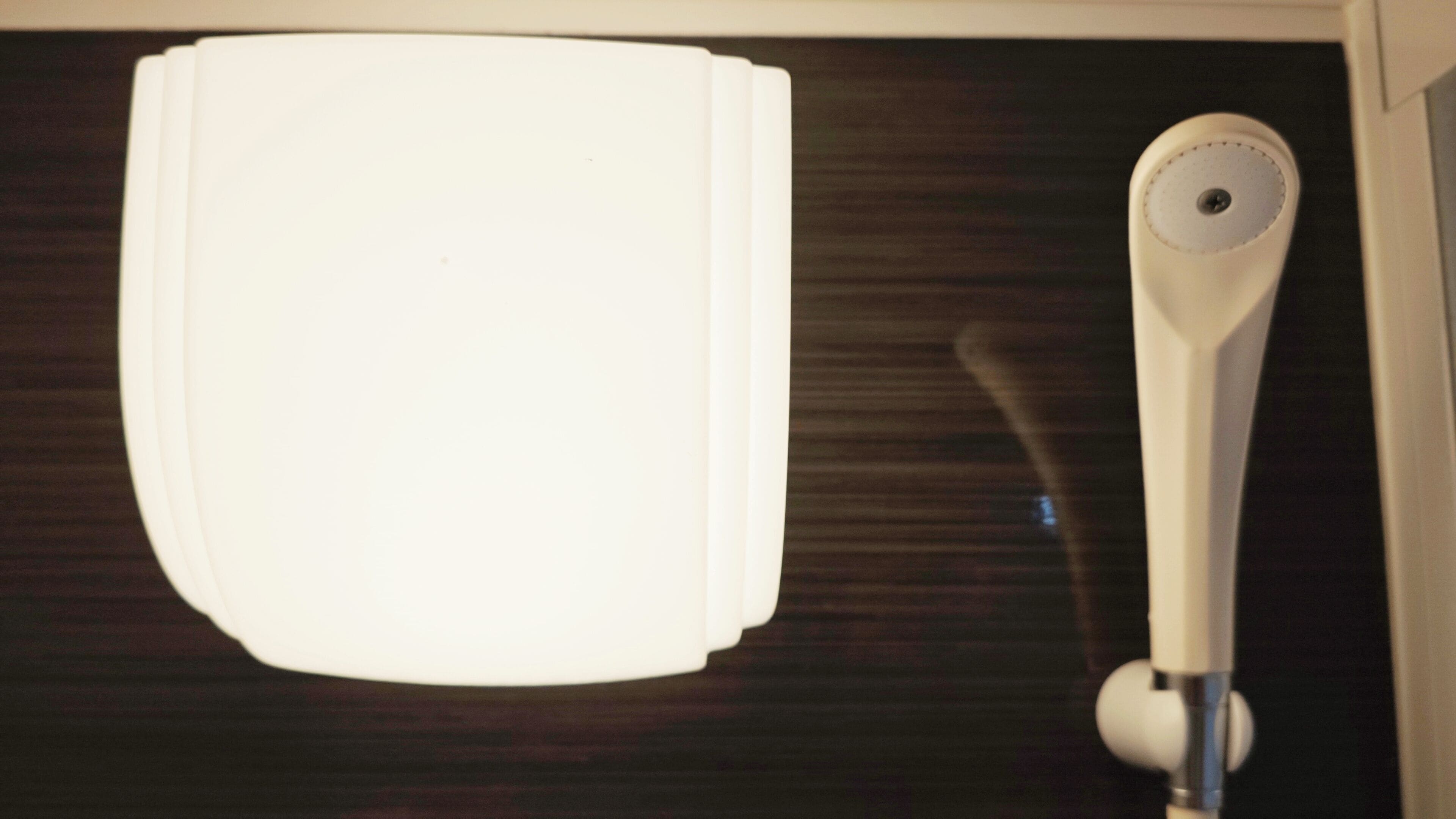 A white object with a circular feature on a dark surface.