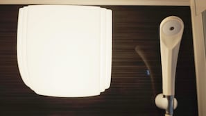 A white object with a circular feature on a dark surface. - Nishisugamo Hotel (Tokyo)