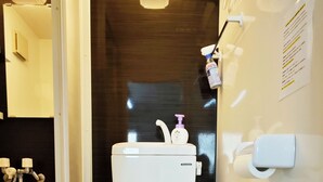 A modern bathroom with a white toilet, a sink, and a mirror.