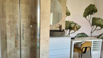 Un bagno con doccia vetrata, un mobile lavabo bianco con uno specchio grande e un affresco murale.