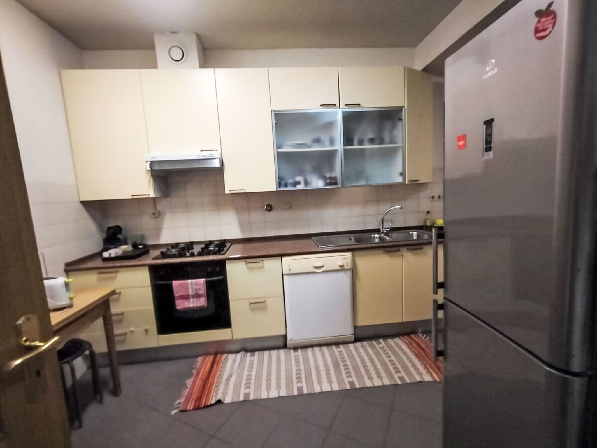 Une cuisine de taille réduite équipée d’une cuisinière, d’un four, d’un lave-vaisselle et d’un réfrigérateur.