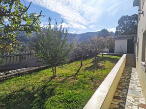 A garden with a paved walkway, a small building, and a view of distant hills. - Walnut House with Private Pool by Interhome (Gondufe)