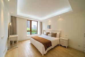 A bedroom with a large bed, bedside tables, a nightstand, a window with a view of buildings, and a ceiling light. - Tyms Gubei International Plaza 3BR Apt (Shanghai)