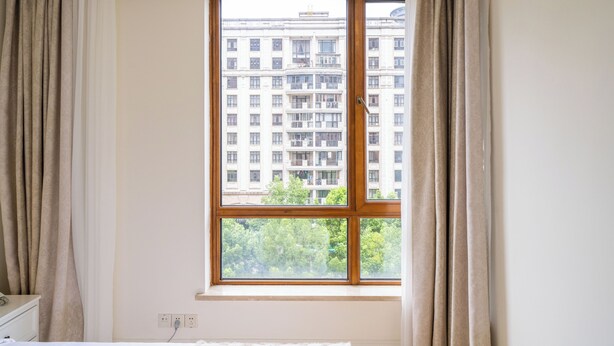 A room with a large window, a bed, and a dresser. - Tyms Gubei International Plaza 3BR Apt (Shanghai)
