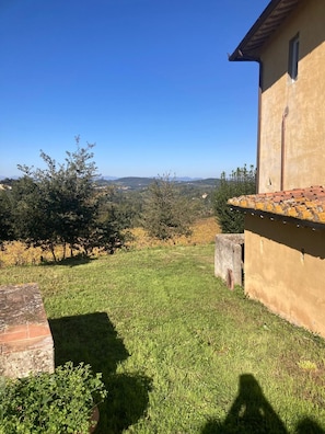 A clear view of a property with a well-maintained lawn, a stone wall, and a building with a tiled roof. - A charming 19th-century Tuscan farmhouse nestled among the vineyards of Chianti Fiorentino (San Casciano in Val di Pesa)