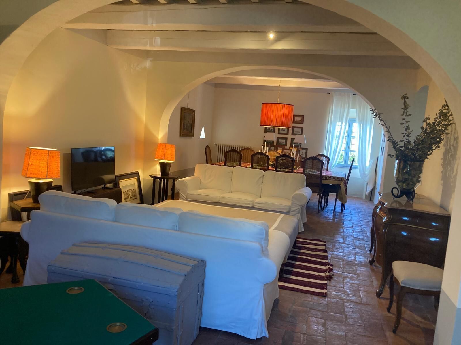 Una sala de estar acogedora con un conjunto de sofá, un televisor y un comedor con sillas y una mesa.