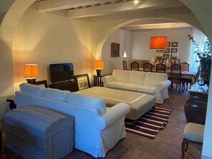 A cozy living room with a sofa set, a television, and a dining area with chairs and a table. - A charming 19th-century Tuscan farmhouse nestled among the vineyards of Chianti Fiorentino (San Casciano in Val di Pesa)