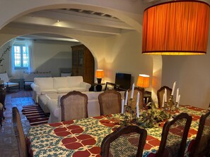 A dining area with a table set for four, surrounded by chairs with a patterned tablecloth. - A charming 19th-century Tuscan farmhouse nestled among the vineyards of Chianti Fiorentino (San Casciano in Val di Pesa)