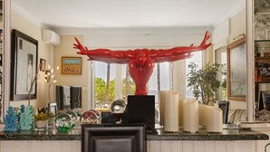 Une cuisine dotée d’une grande fenêtre, d’une sculpture rouge et de divers ustensiles de cuisine.