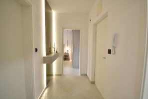 A narrow hallway with a light fixture on the left, a telephone on the right, and a door at the end. - Golden Pearl- Exclusive Seaview Aparatment with Spacious Teracce and Jacuzzi (Split)