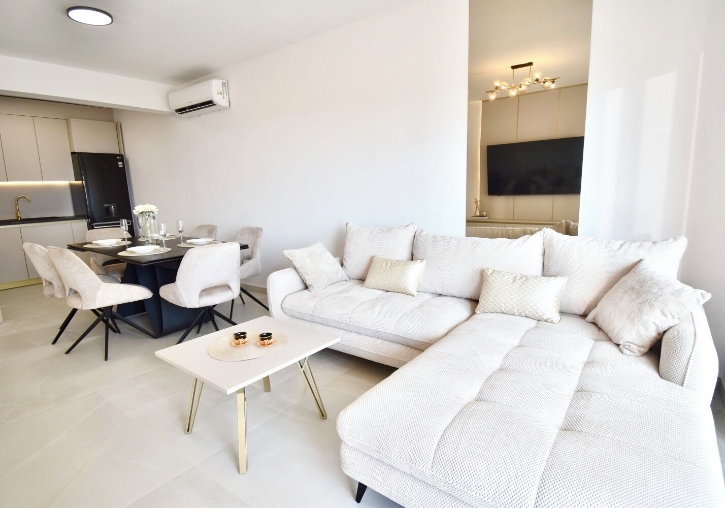 Ein modernes Wohnzimmer mit Ecksofa, Essbereich und Küche.