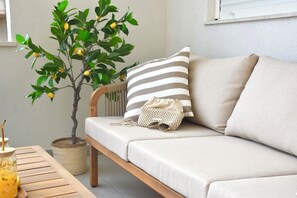 A sofa with striped pillows, a woven bag, and a potted lemon tree. - Golden Pearl- Exclusive Seaview Aparatment with Spacious Teracce and Jacuzzi (Split)