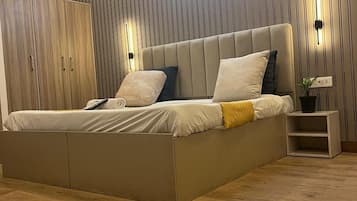 Un dormitorio moderno con una cama grande, un armario de madera y un aplique de pared.