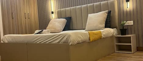 Una camera da letto moderna con un letto grande, un'armadio in legno e una lampada a parete.