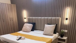 A modern bedroom with a large bed, bedside tables, and a wall-mounted light fixture.