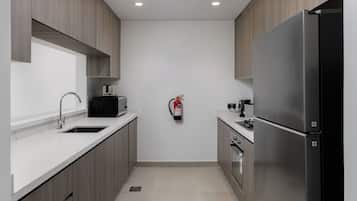 Una cocina moderna con refrigerador de acero inoxidable, microondas, tostadora y pileta.
