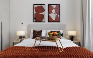 A hotel room with a bed, two bedside lamps, a fruit bowl, and abstract artwork on the wall. - Maison Privee - Serene Yas Island Hideaway w/ Resort Facilities (Abu Dhabi)