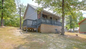 A two-story cabin with a balcony, surrounded by trees. - Steps to Lake! Cabin w/ Water Views in Hot Springs (Hot Springs)