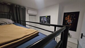 Ein Etagenbett mit Kopfteil, ein Fenster mit Vorhängen und zwei Wandposter mit Tiger-Motiven.