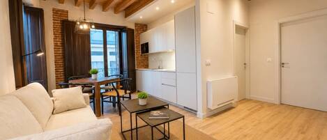 A modern living room with a sofa, a coffee table, and a dining area with a table and chairs.
