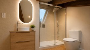 A modern bathroom with a shower, toilet, and vanity. - María de Molina - Apartamento Deluxe (Avila)