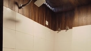 A bathroom with a toilet, sink, and shower. - My Island Residency (Port Blair)