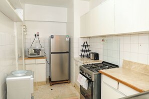 A compact kitchen with a refrigerator, microwave, toaster, and gas stove. - Cozy, comfortable and child friendly (Nairobi)