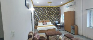 Habitación de hotel con cama, escritorio, armario y ventana.