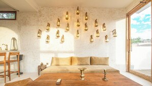 Ein Zimmer mit Holztisch, einer Couch und einer Wandleuchte.