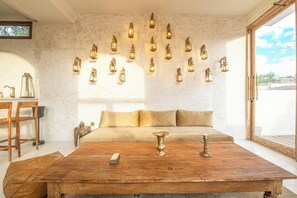 A room with a wooden coffee table, a sofa, and a wall-mounted light fixture. - Chic 3BR Mediterranean Haven, Heart of Uluwatu (Pecatu)