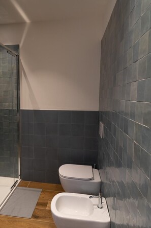 Ein Badezimmer mit Dusche, Toilette und Bidet.